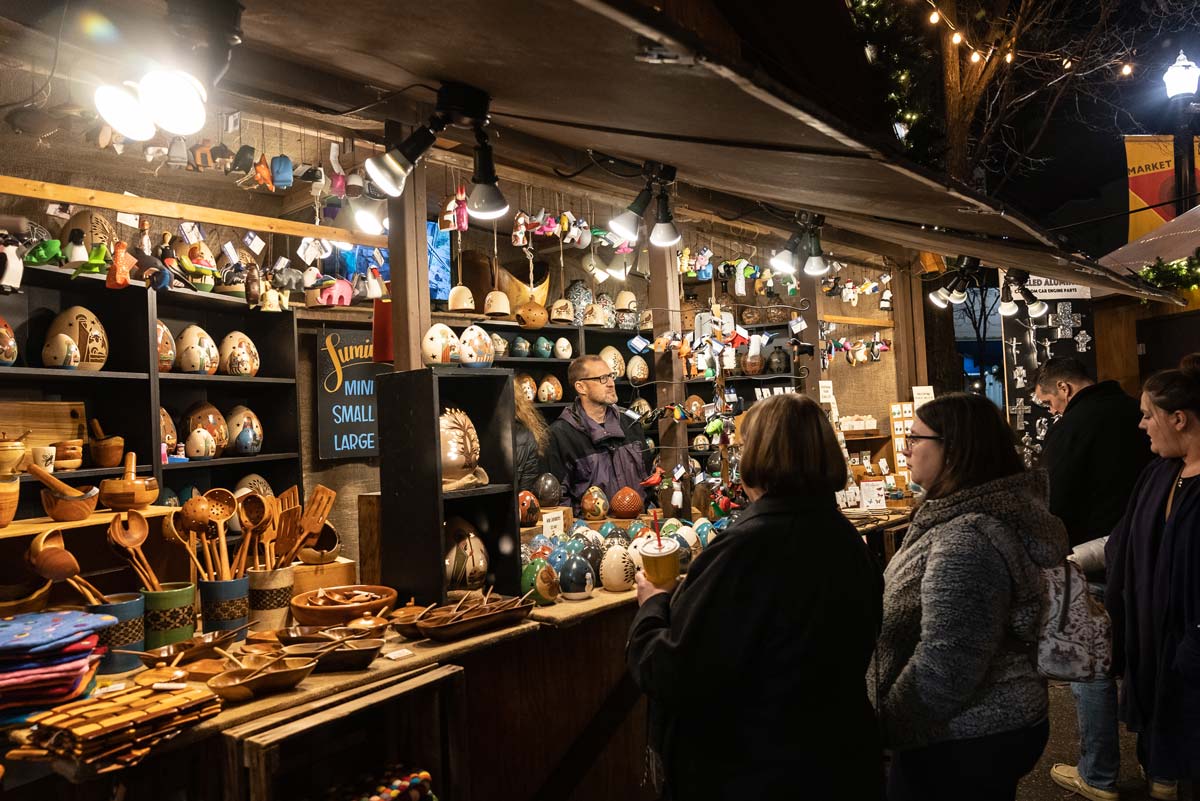 A group of women speak with a vendor at Peoples Gas Holiday Market, one of the best christmas markets in the United States for families.