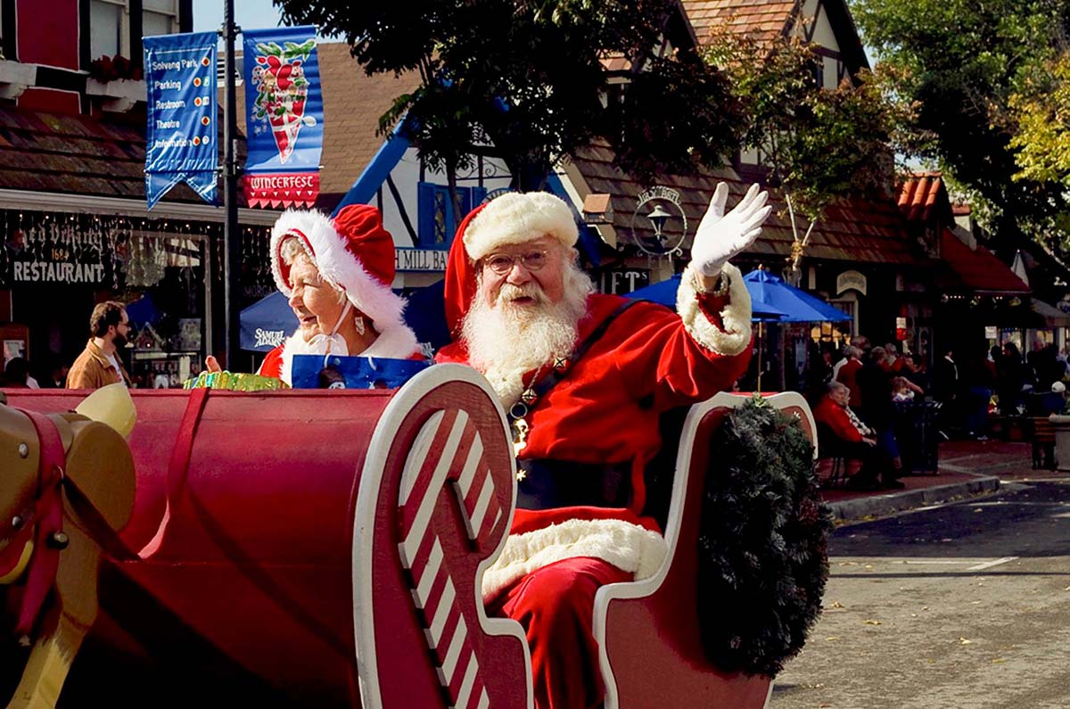 Mr. and Mrs. Clause wave from a parade sleigh during the Solvang Julefest, one of the best christmas markets in the United States for families.