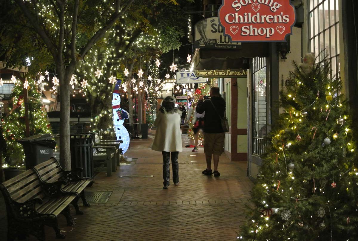 Several people meander a decorated street in California during the Solvang Julefest.