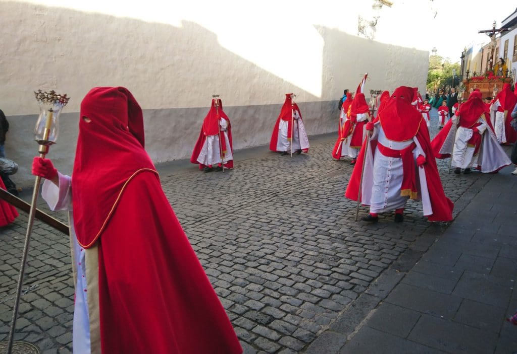 Several religious members walk along a street in Tenerife during a parade for Semana Santa during Easter week.