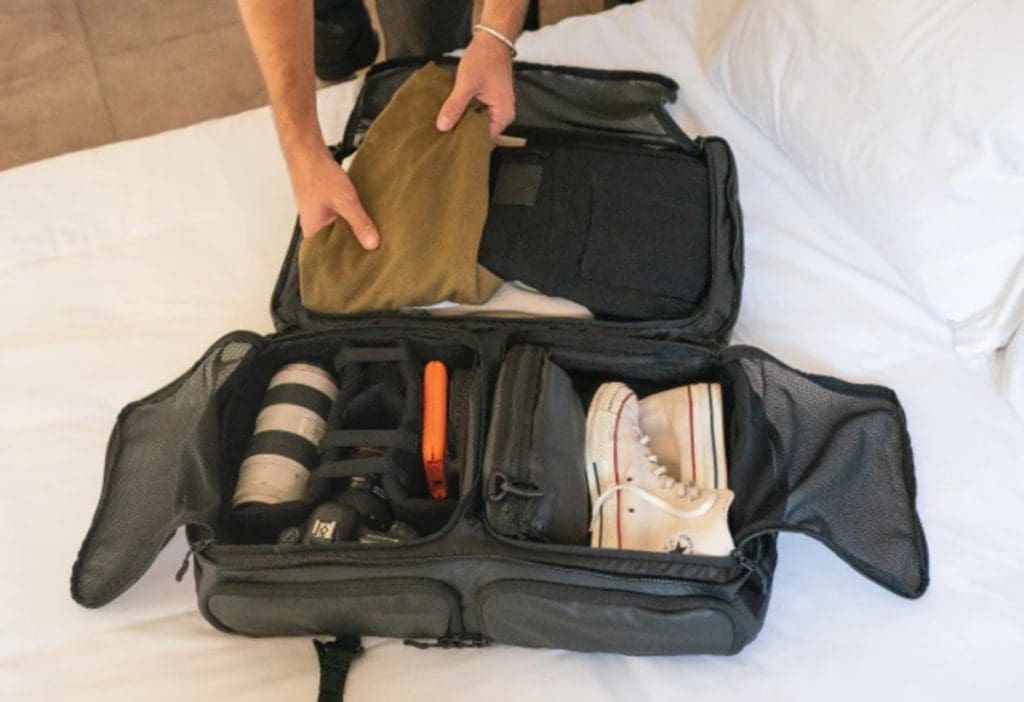 Hands reach out to pack a Wandrd duffle bag before embarking on a family trip.