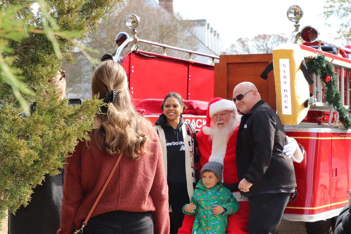 Several people pose with Santa and a fire truck at Christmas Market on Main in Yorktown.