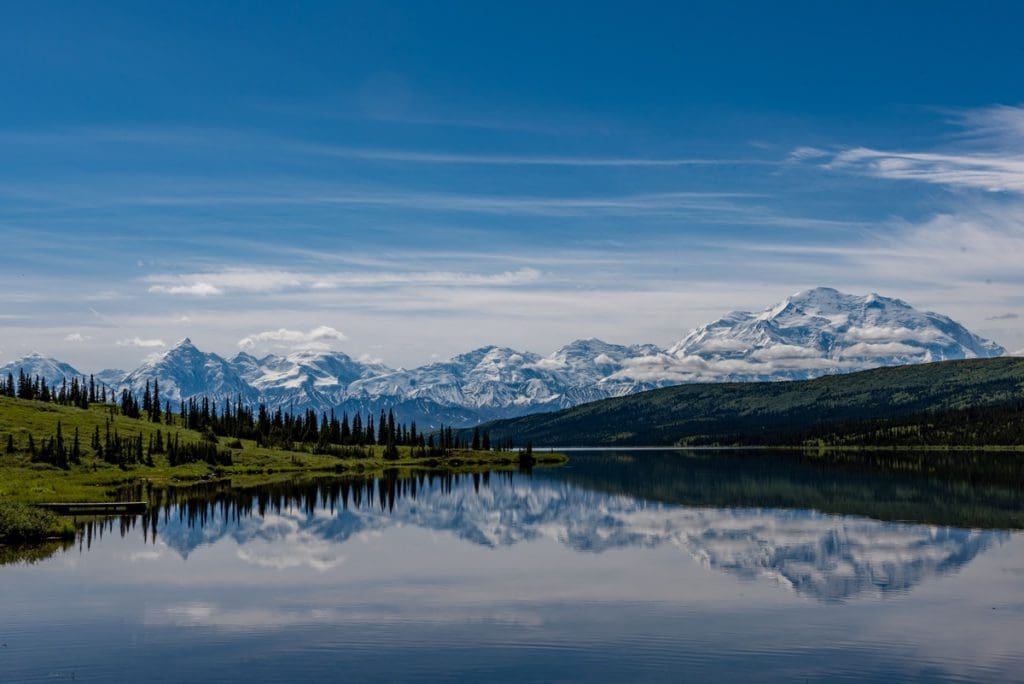 Snow-capped mountains stand tall over Wonder Lake in Denali National Park.