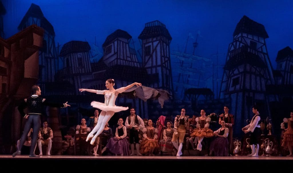 Ballet dancers preform on stage, tickets to a concert or show are one of the best family travel gifts of the year.