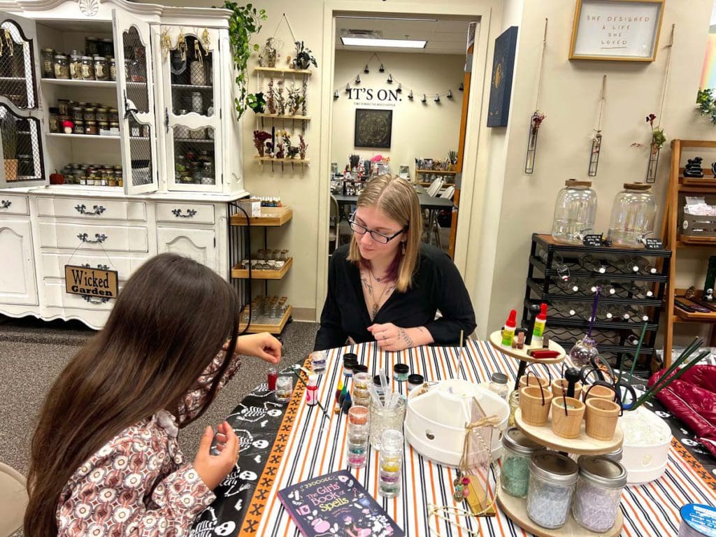 A young girl and a shop employee talk over some items at Witch Slapped, one of the must stops on this weekend getaway itinerary for families in Pittsfield.
