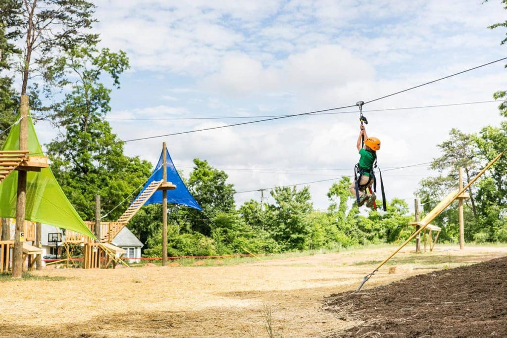 A child moves along a zipline at The Adventure Center of Asheville.