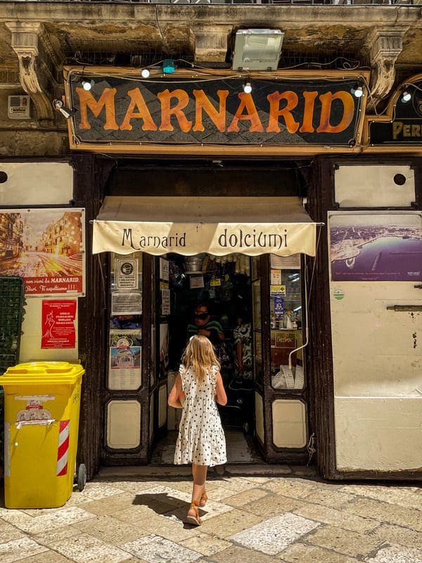 A young girl walks into the oldest candy store in Bari.