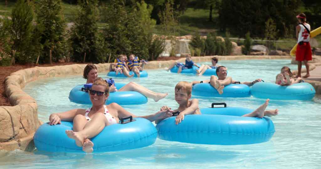 A family floats down a lazy river at Ocean Breeze Water Park in individual blue tubes.