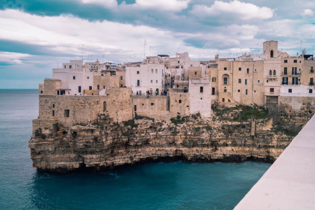 A city view of Polignano a Mare along the ocean, one of the best places to visit in Puglia with kids.