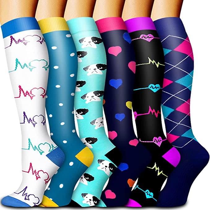A product shot of six colorful compression socks, one of the best products for sleeping on long international flights with kids.