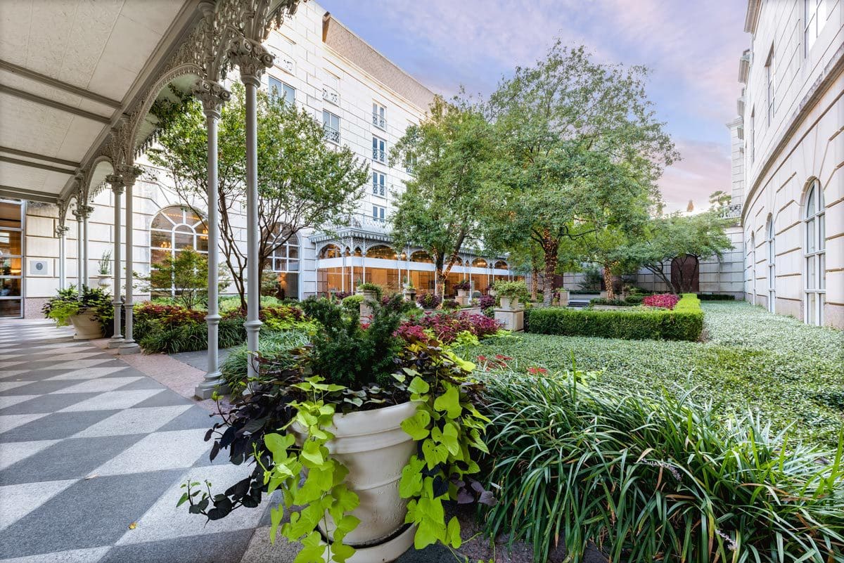 A lovely outdoor courtyard with lush greenery at Hotel Crescent Court, one of the best hotels in Dallas for families.
