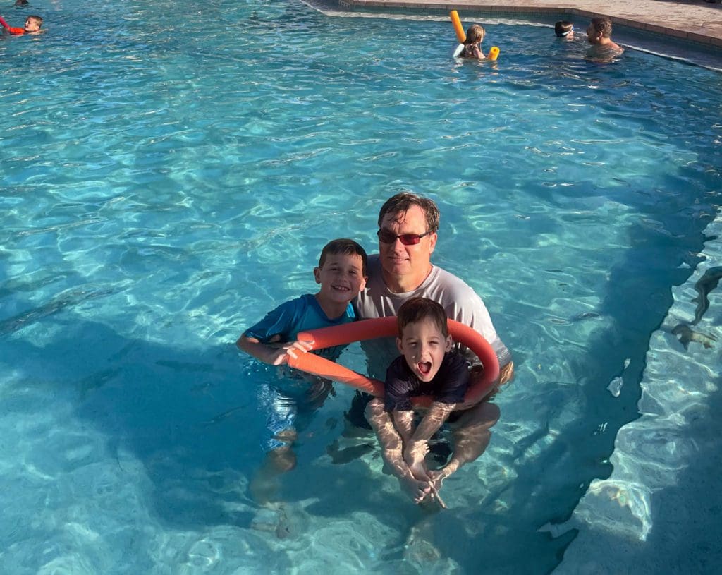 A dad and his two young boys swim together in the hotel pool at Casa Marina Hotel.