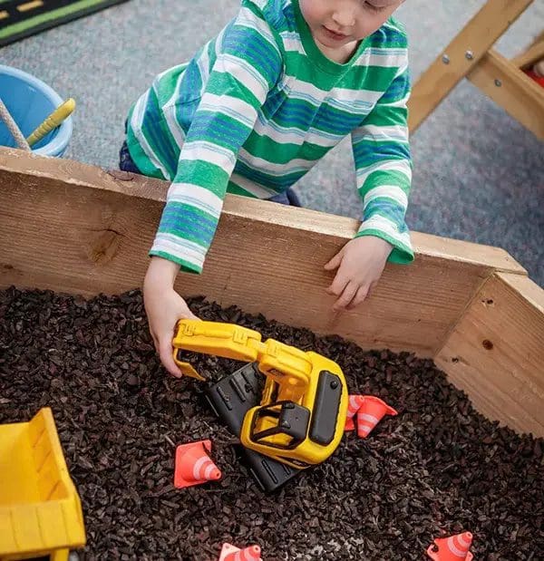 A young child playing at a construction site-style exhibit at Mountain Top Explorium.