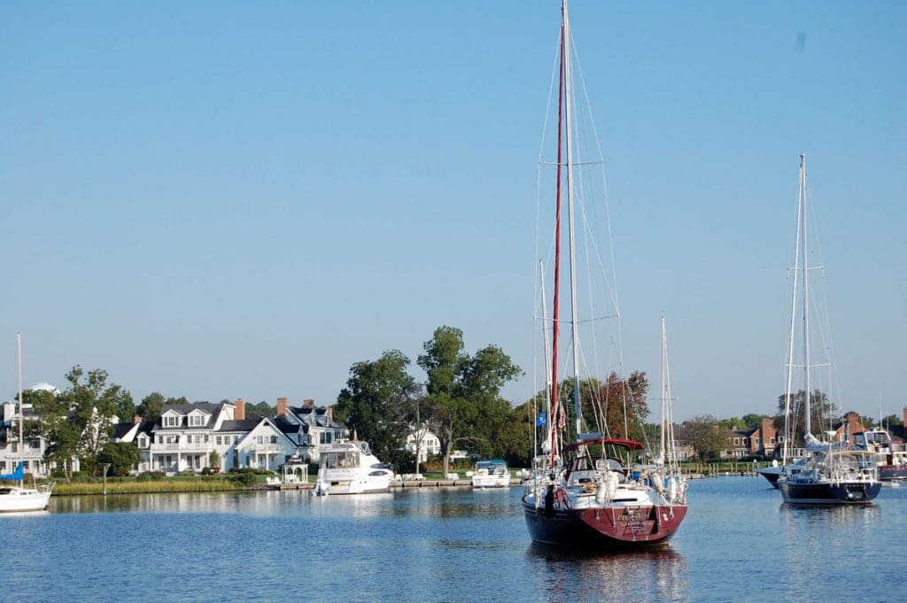 The harbor of St. Michaels, Maryland, with a few boats anchored, on a clear blue day, one of the best Labor Day Weekend getaways near DC for families.