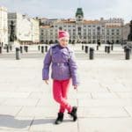 A young girl stands in a piazza in Trieste, one of the best neighborhoods to stay in Rome with kids.