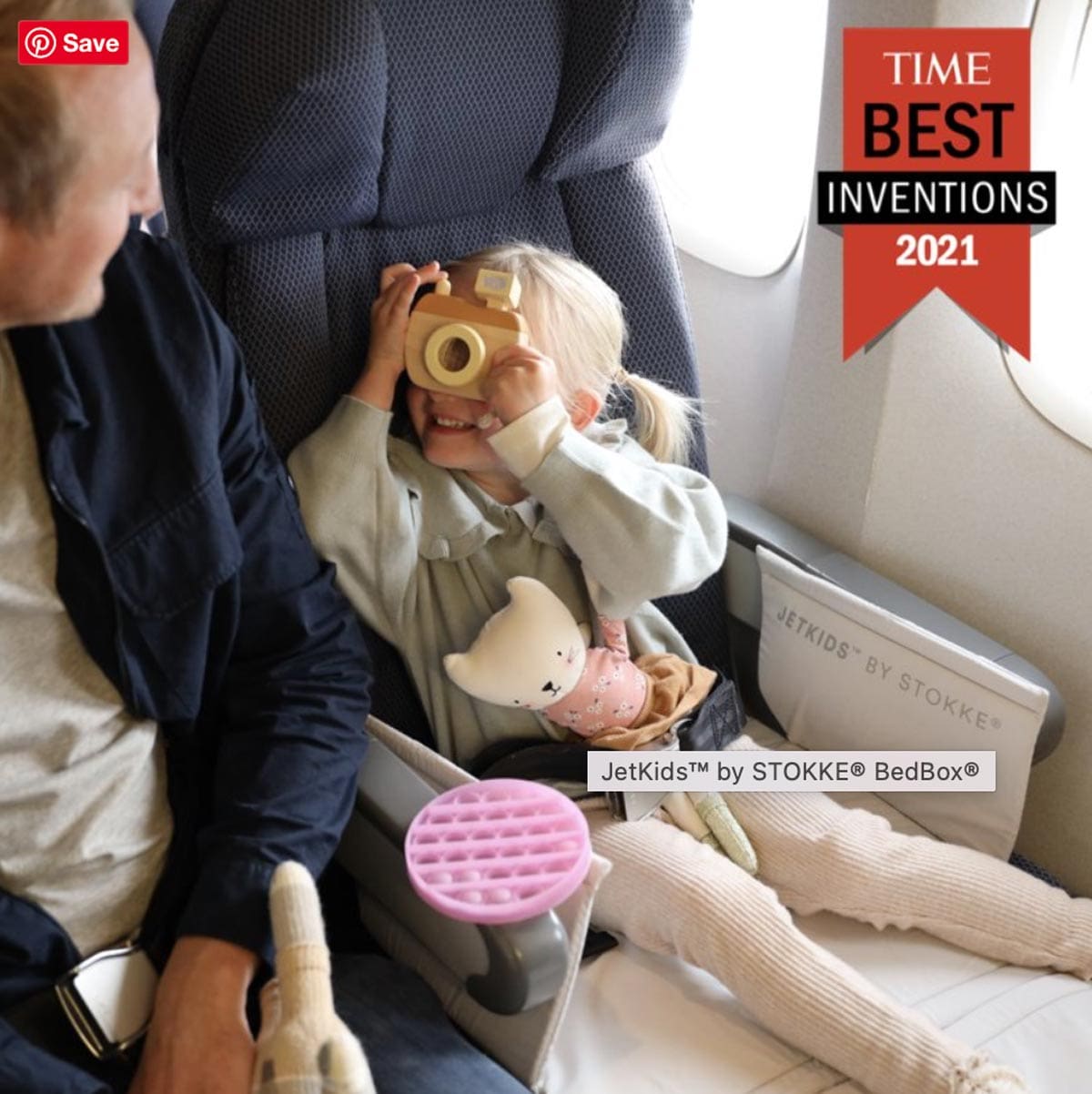 A little girl uses her Jetkids by Stokke Bedbox, one of the best products for sleeping on long international flights with kids.