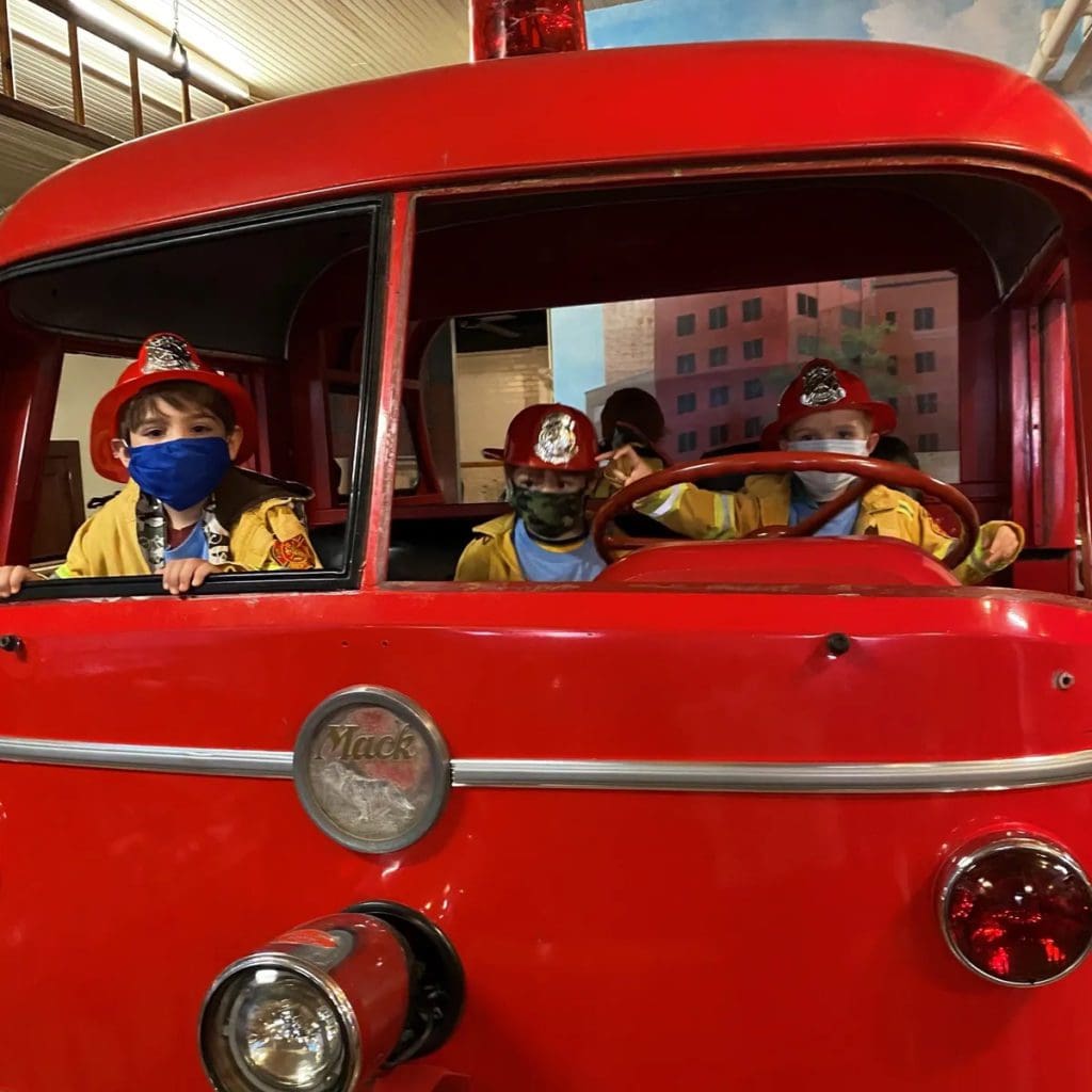 Kids enjoy a large truck display at the Denver Firefighters Museum.