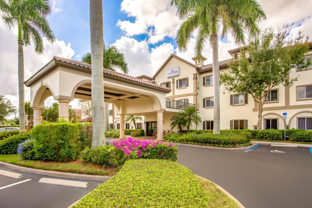 The drive-up entrance to the palm-studded Hawthorn Suites by Wyndham Naples, one of the best hotels in Naples for families.
