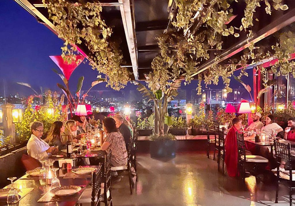 Several people enjoy a rooftop meal at a restaurant in Istanbul, a great experience for on a Turkey itinerary for families.