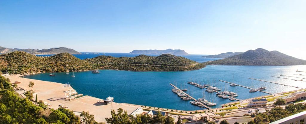 A scenic view of Kas in Turkey, featuring blue waters and a sandy shoreline.