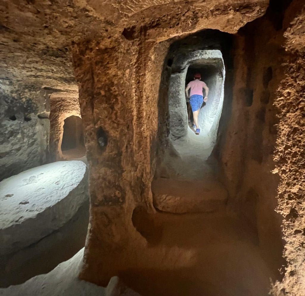 A young boy runs through a cave in Kaymakli, a great stop on a Turkey itinerary for families.