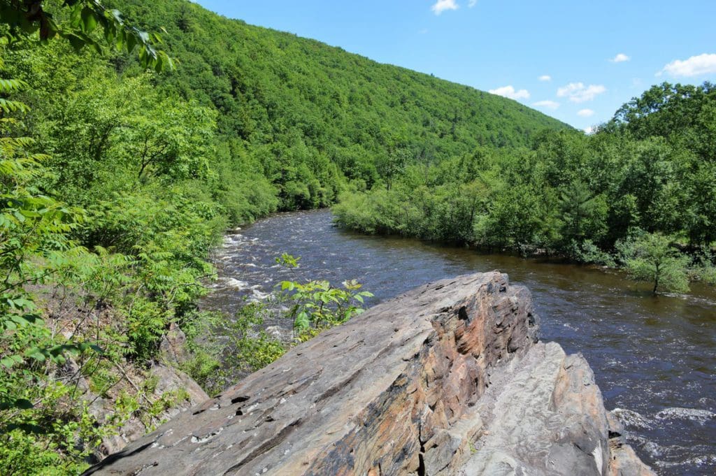 A large flat rock juts out over the water in Lehigh Gorge State Park, located in the Pocono Mountains.