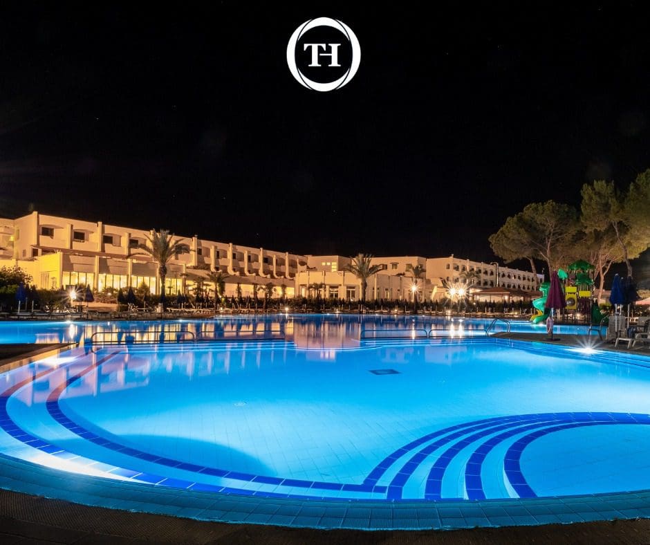The lovely outdoor pool and large resort at TH Marina Di Pisticci - Ti Blu Village at night.