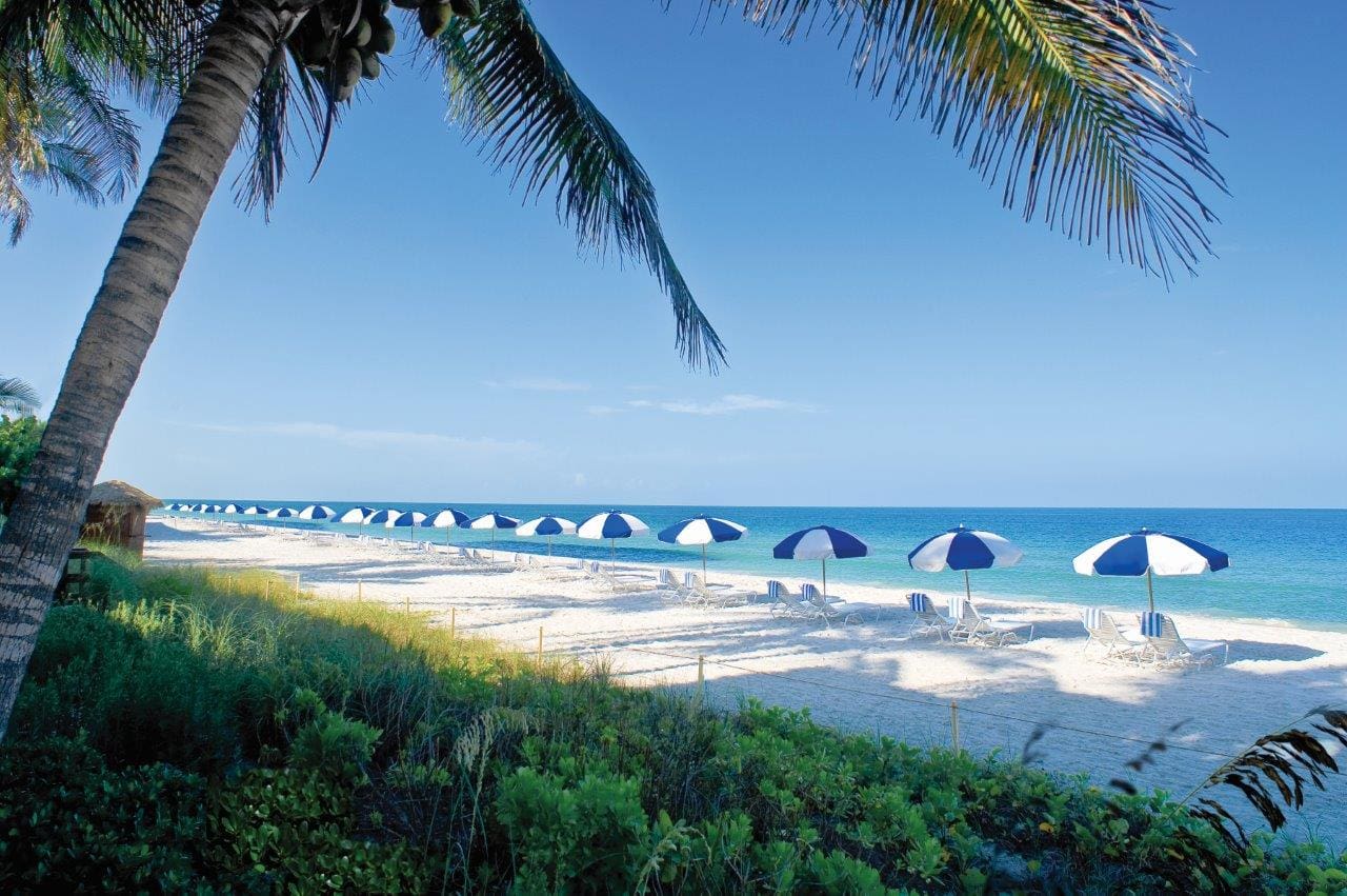 The beach with beach umbrellas on a sunny day at LaPlaya Beach & Golf Resort.
