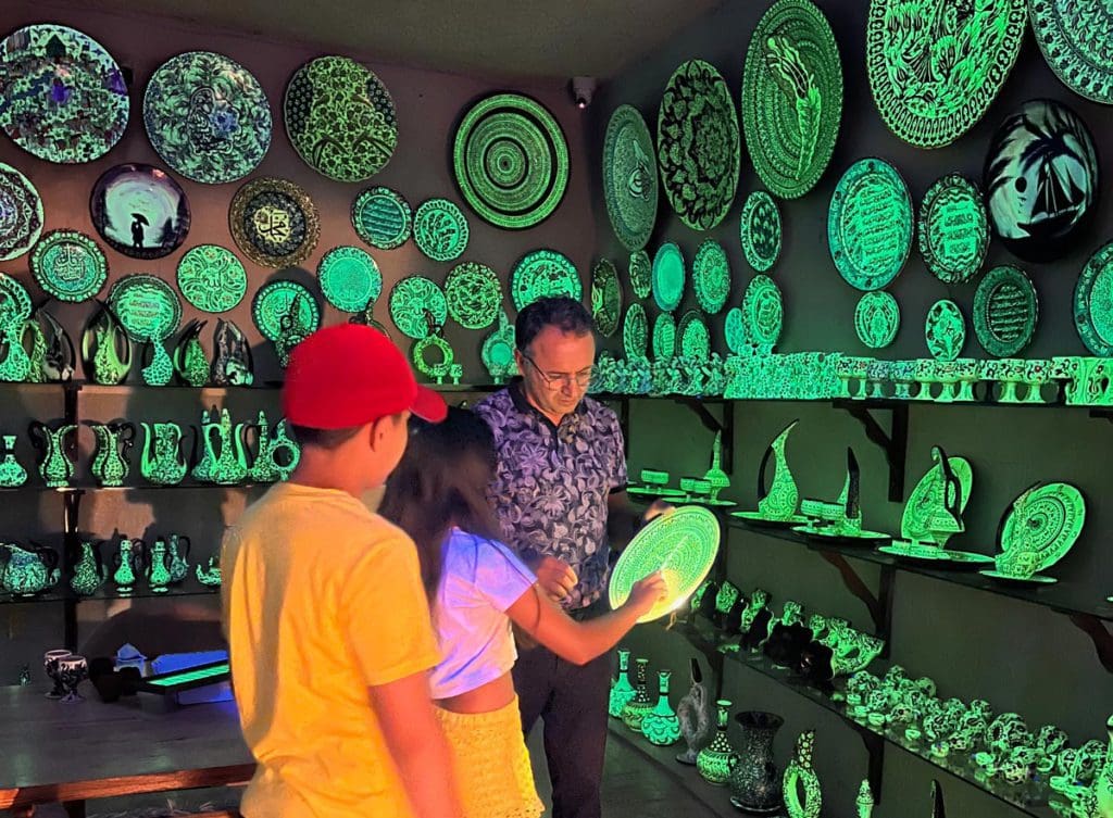 Two kids speak to a shop owner to learn about local pottery in Cappadocia.
