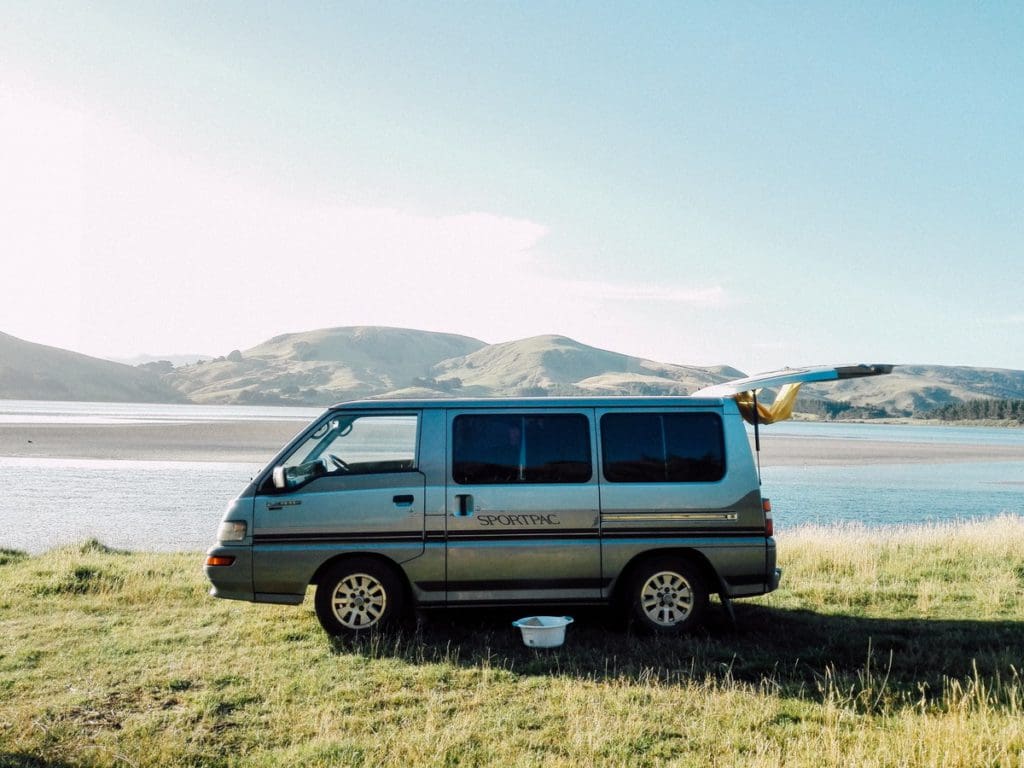 A camper van is parked along a lake near Dunedin, New Zealand.