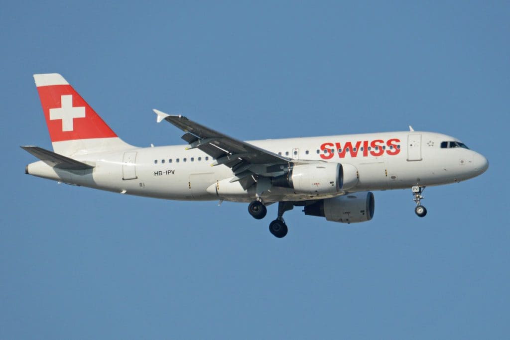 A Swiss International Air Lines plane in flight with blue skies.