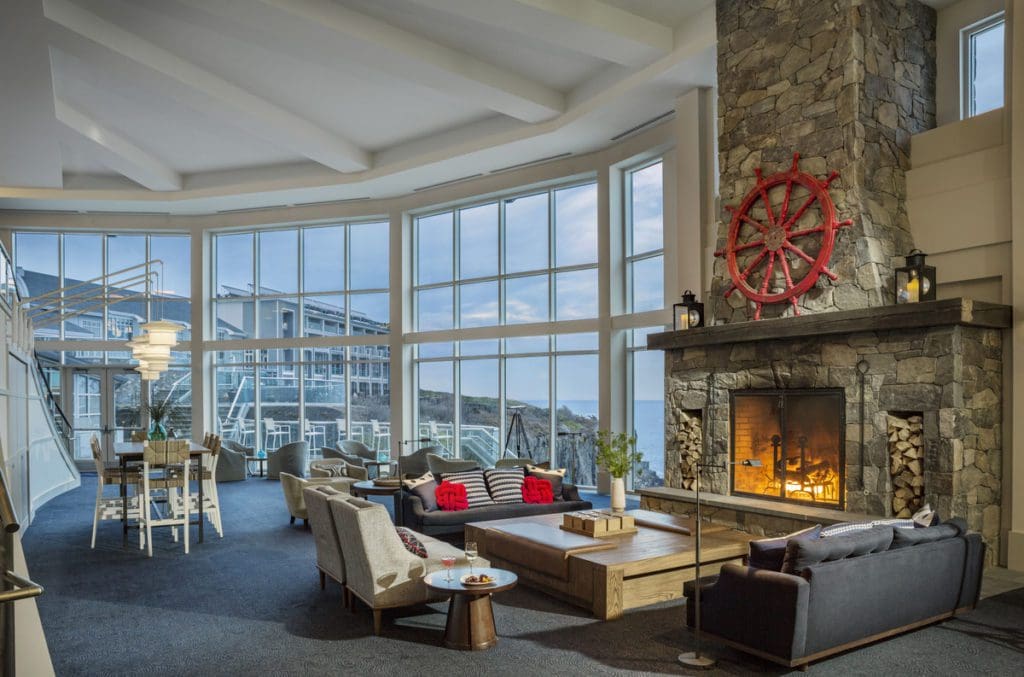 The cozy lounge with fireplace and view of the sea at Cliff House Maine.