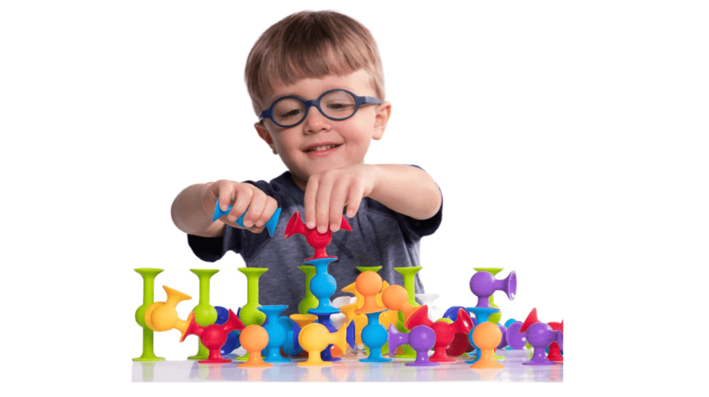 A product shot of a young boy playing with Squigz.