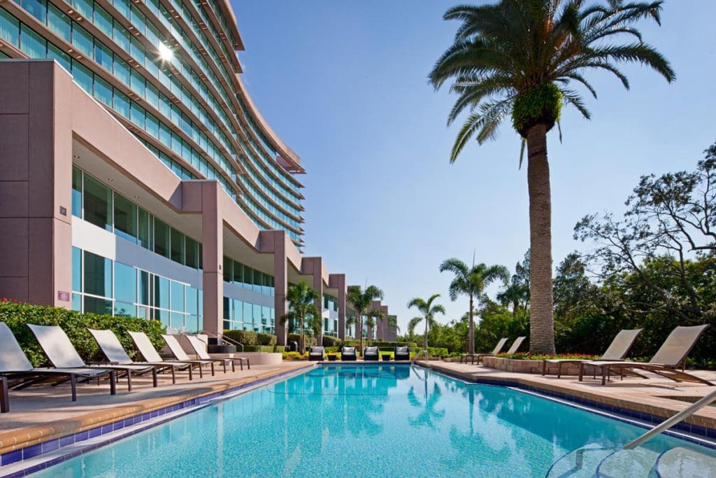 The outdoor pool, flanked by the hotel building on one side and lush greenery on the other, at Grand Hyatt Tampa Bay.