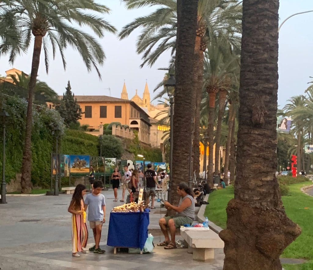Two kids look at a table of wares from a street seller in Palma, Mallorca.