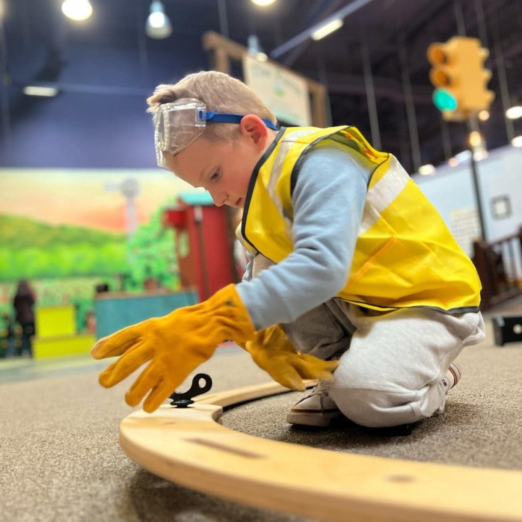 A young boy plays at a car exhibit at Pretend City Children's Museum.