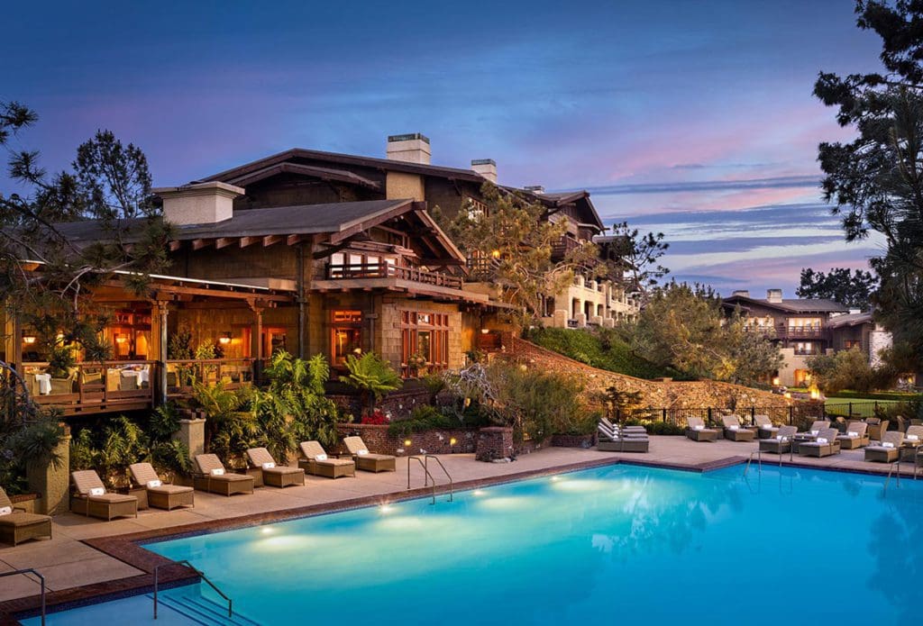 The outside of The Lodge at Torrey Pines with a view of the pool deck at night.