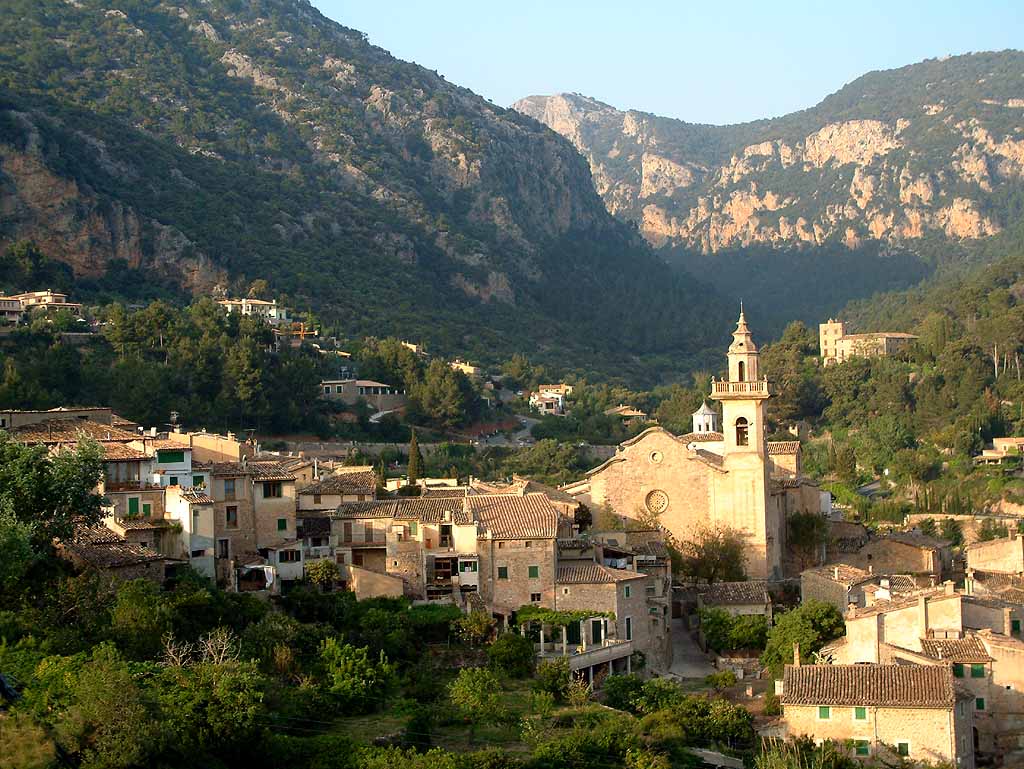 A scenic view of the history town of Valldemossa, tucked between forest and mountains.