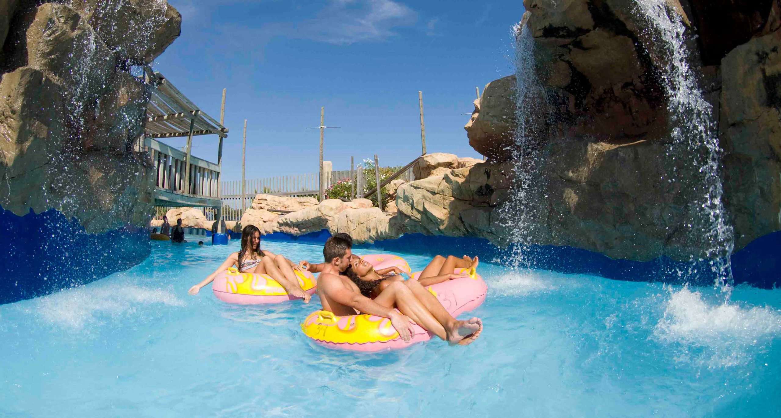 Several people float down a lazy river on large tubes at Western Waterpark Magaluf.