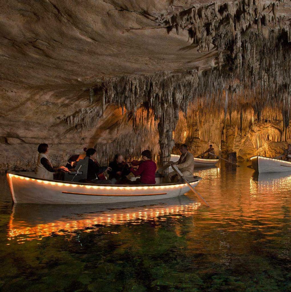 A boat floats through a watery cavern while exploring Cuevas del Drach.