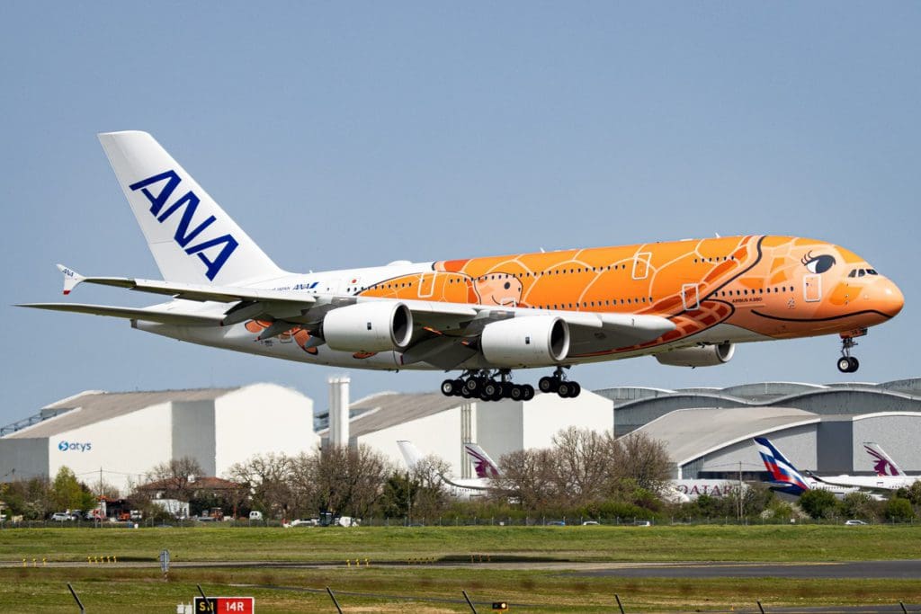 A colorfully-painted All Nippon Airways plane takes off from an airport, one of the best airlines for kids.