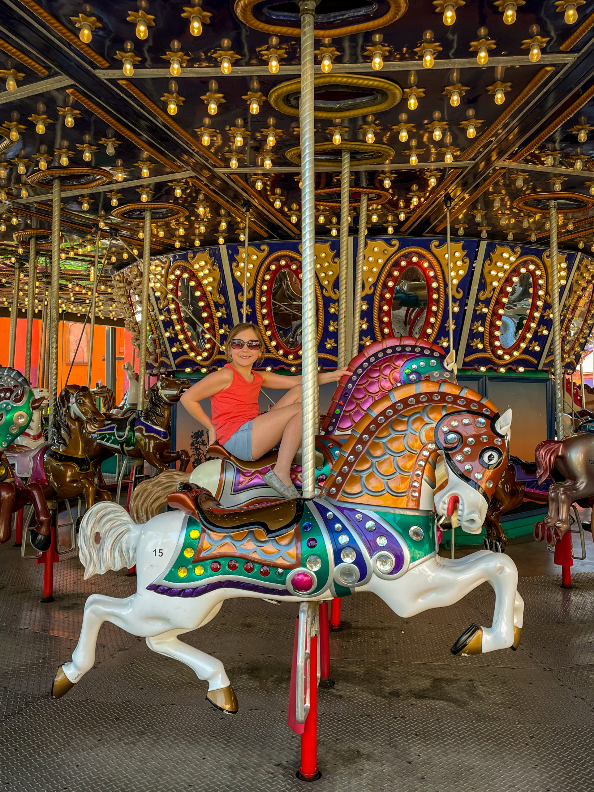 A young girl sits on a carousel horse at Busch Gardens® Tampa Bay.