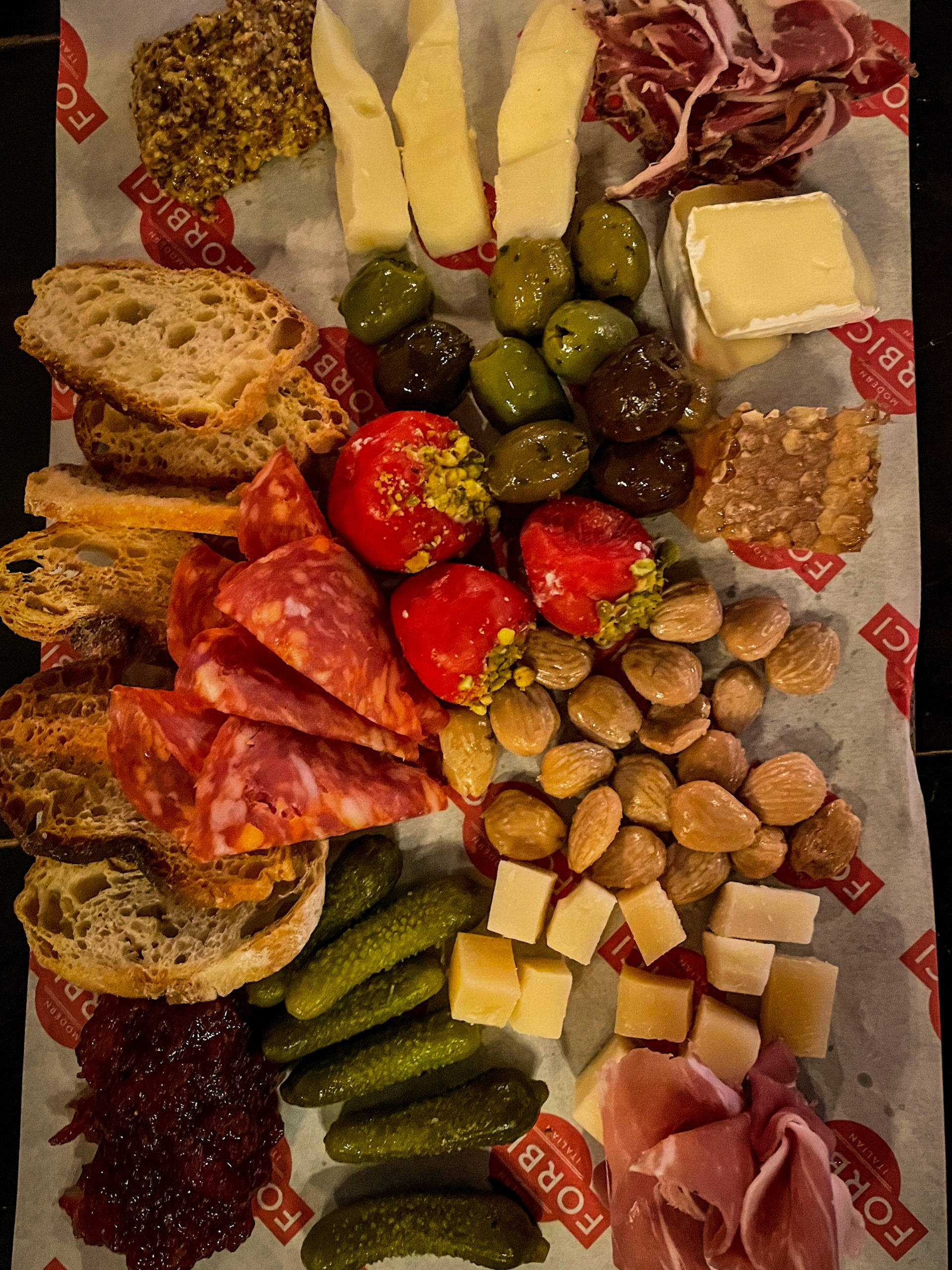 A scrumptious charcuterie board at Forbici Modern Italian in the Hyde Park neighborhood of Tampa Bay, featuring bread, salami, cheese, nuts, and more.