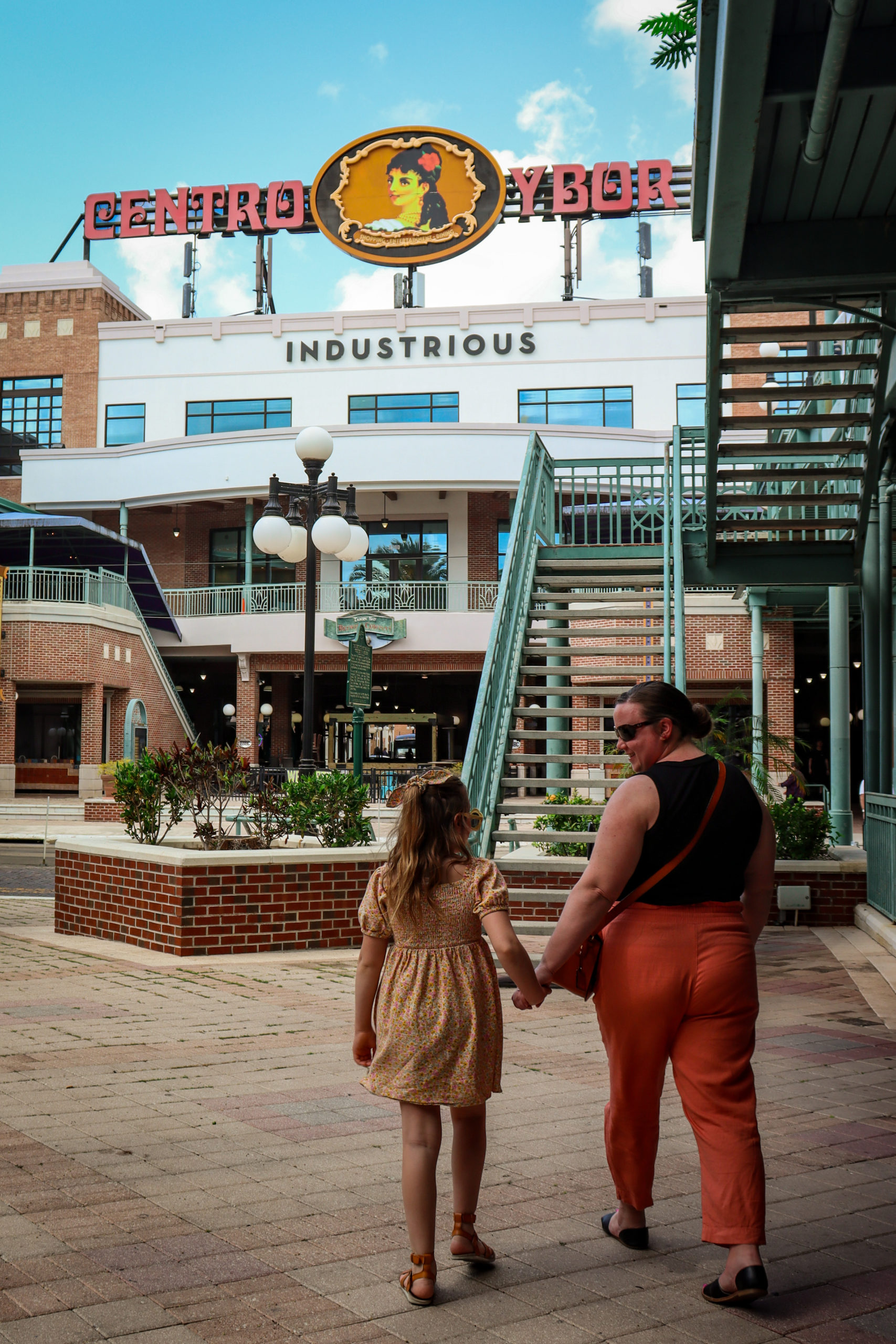 A mom and her young daughter walk around Ybor City.