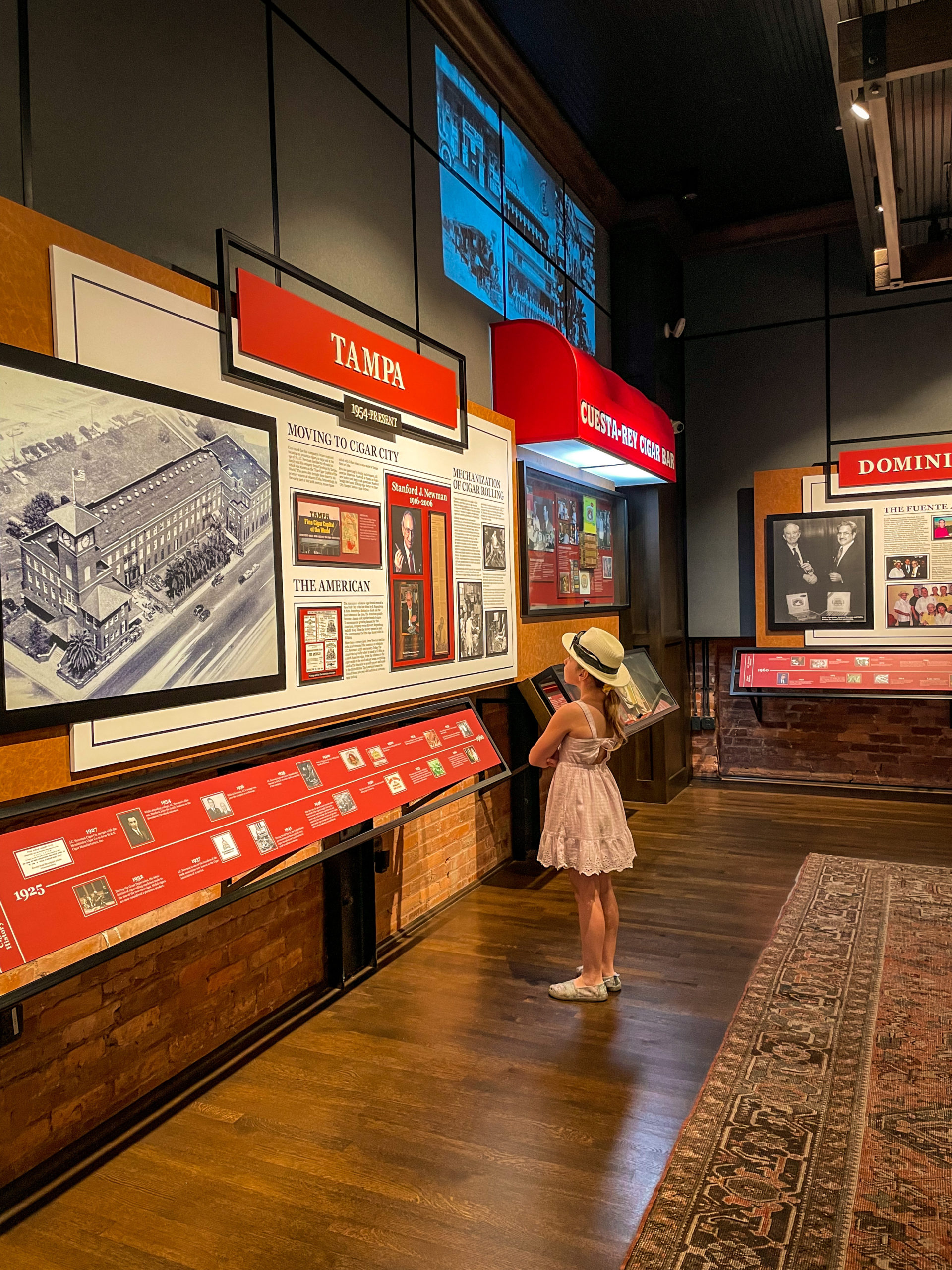 A young girl reads museum placards while exploring J.C. Newman Cigar Co. in Ybor City, a must do when you visit Tampa Bay with Kids.