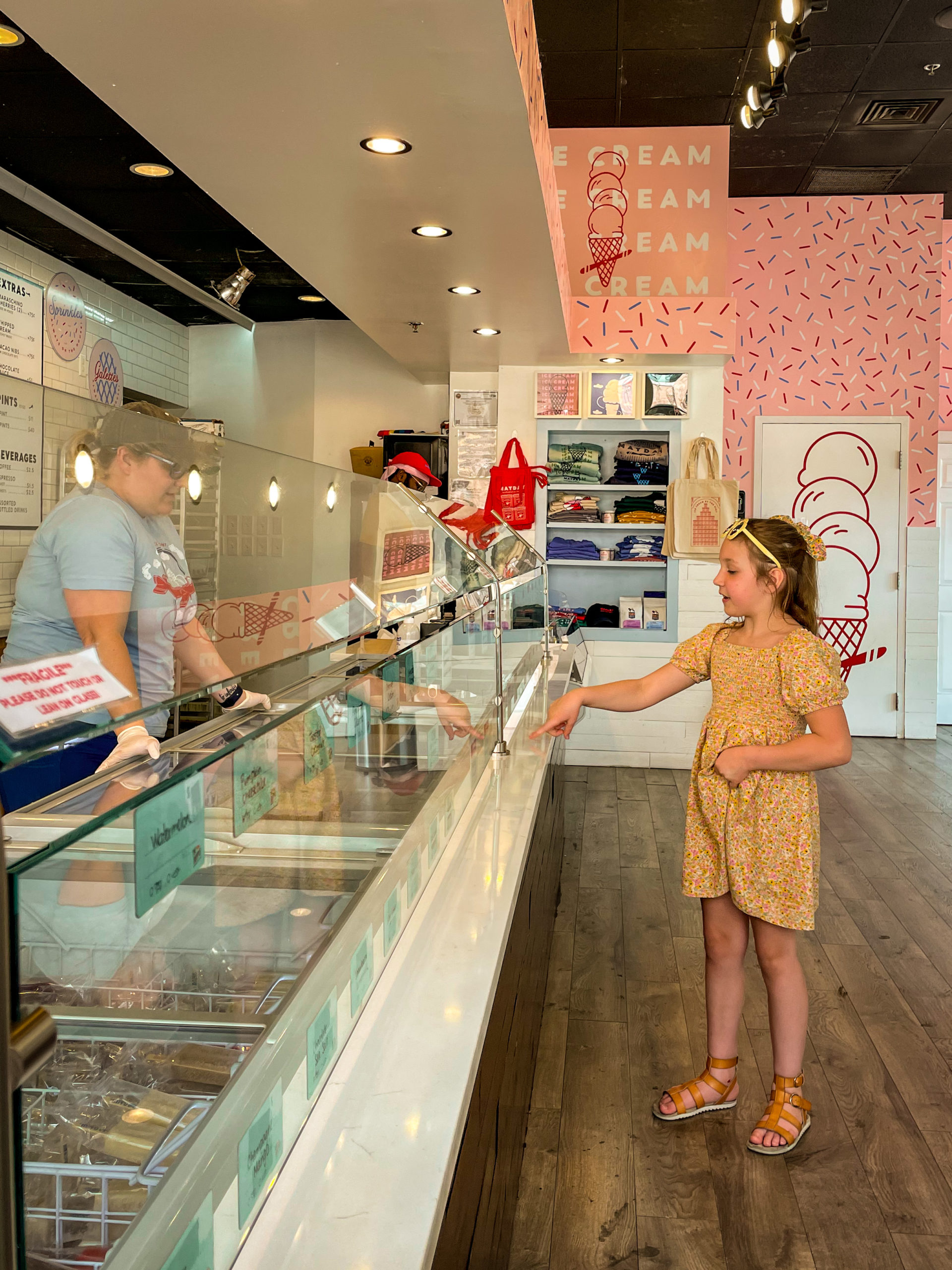 A young girl points to the ice cream she wants at Mayday Ice Cream in Ybor City, a must eat when you visit Tampa Bay with Kids.
