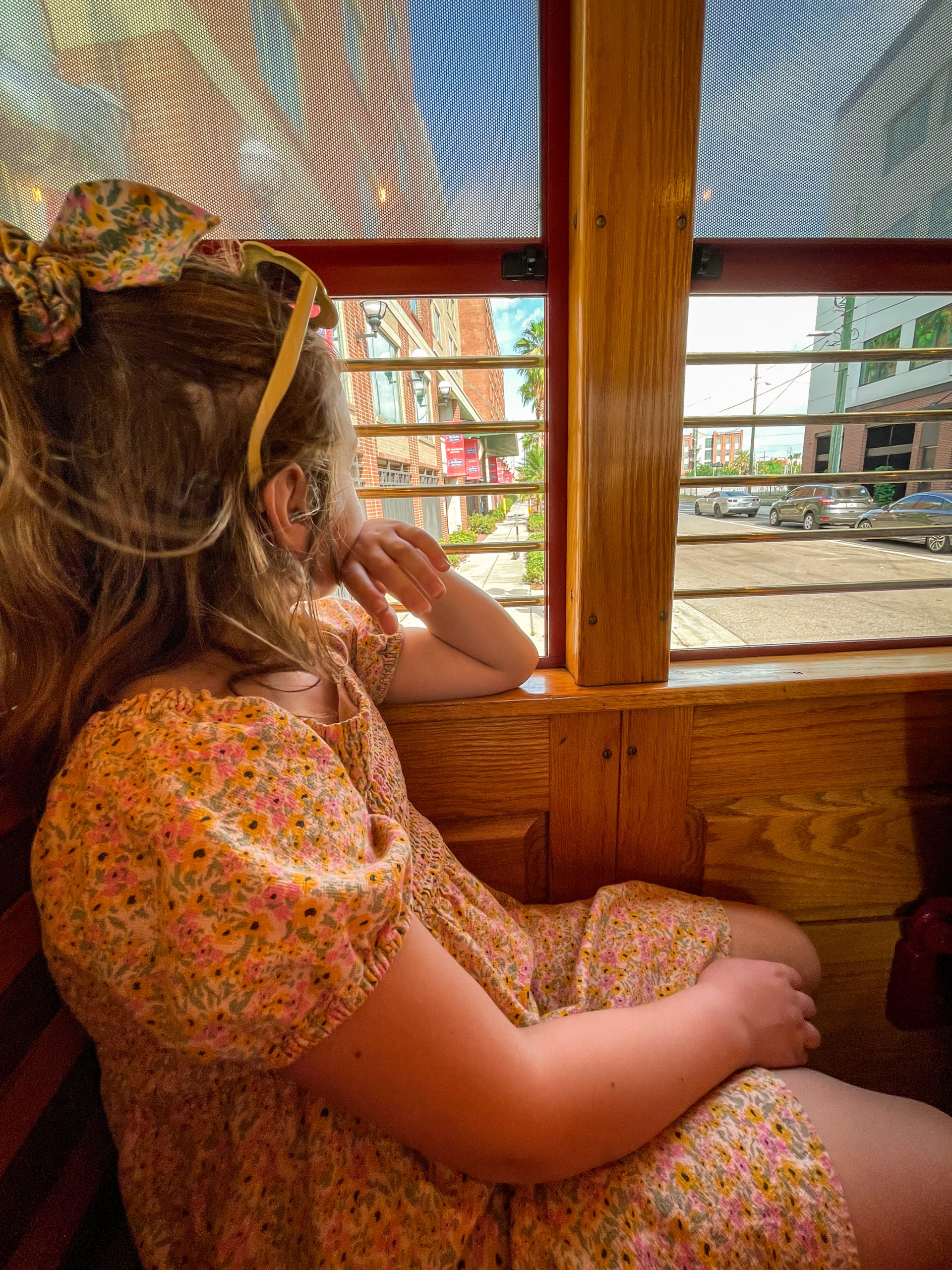 A young girl looks out the window while riding on the TECO Streetcar in historic Ybor City.