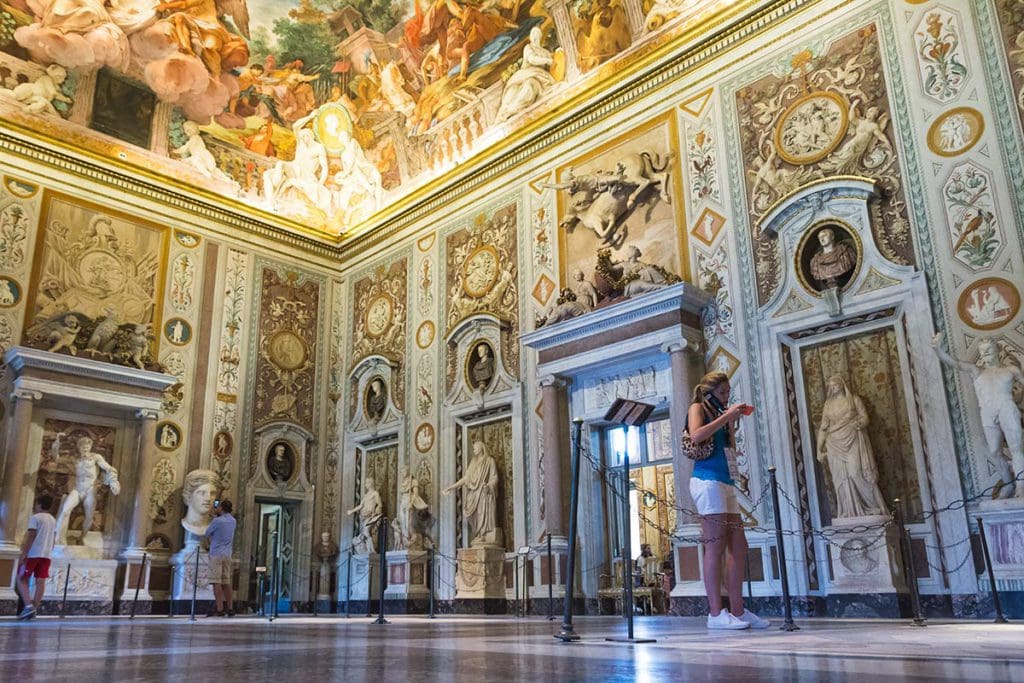 A woman walks around one of the opulent rooms of the Borghese Gallery.
