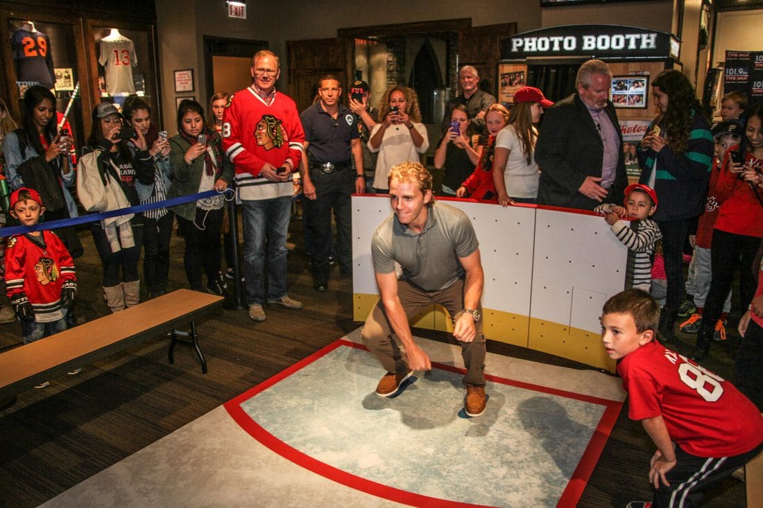 Several people enjoy an interactive exhibit at the Chicago Sports Museum.