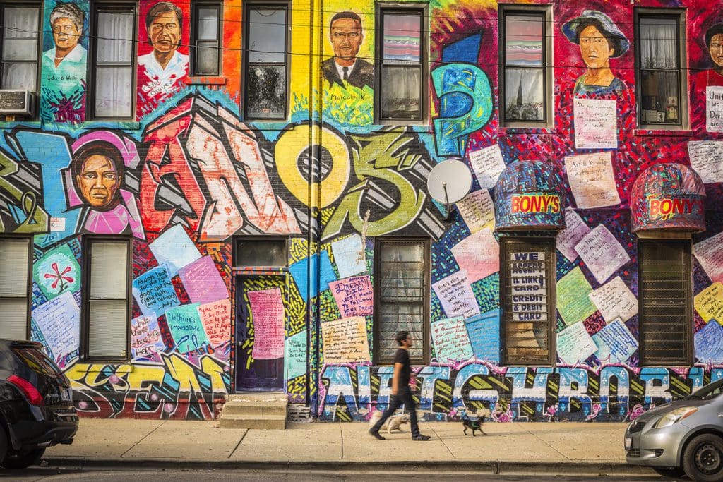 A man walks past a colorful mural in the Pilsen neighborhood of Chicago.